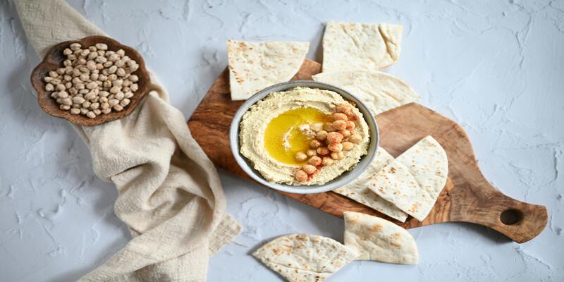 A bowl of hummus and pita bread AI-generated content may be incorrect.
