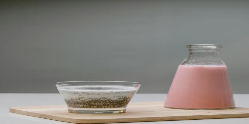 A glass bowl with a mixture in it next to a pink liquid AI-generated content may be incorrect.